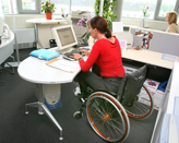 Muller na cadeira de rodas con ordenador