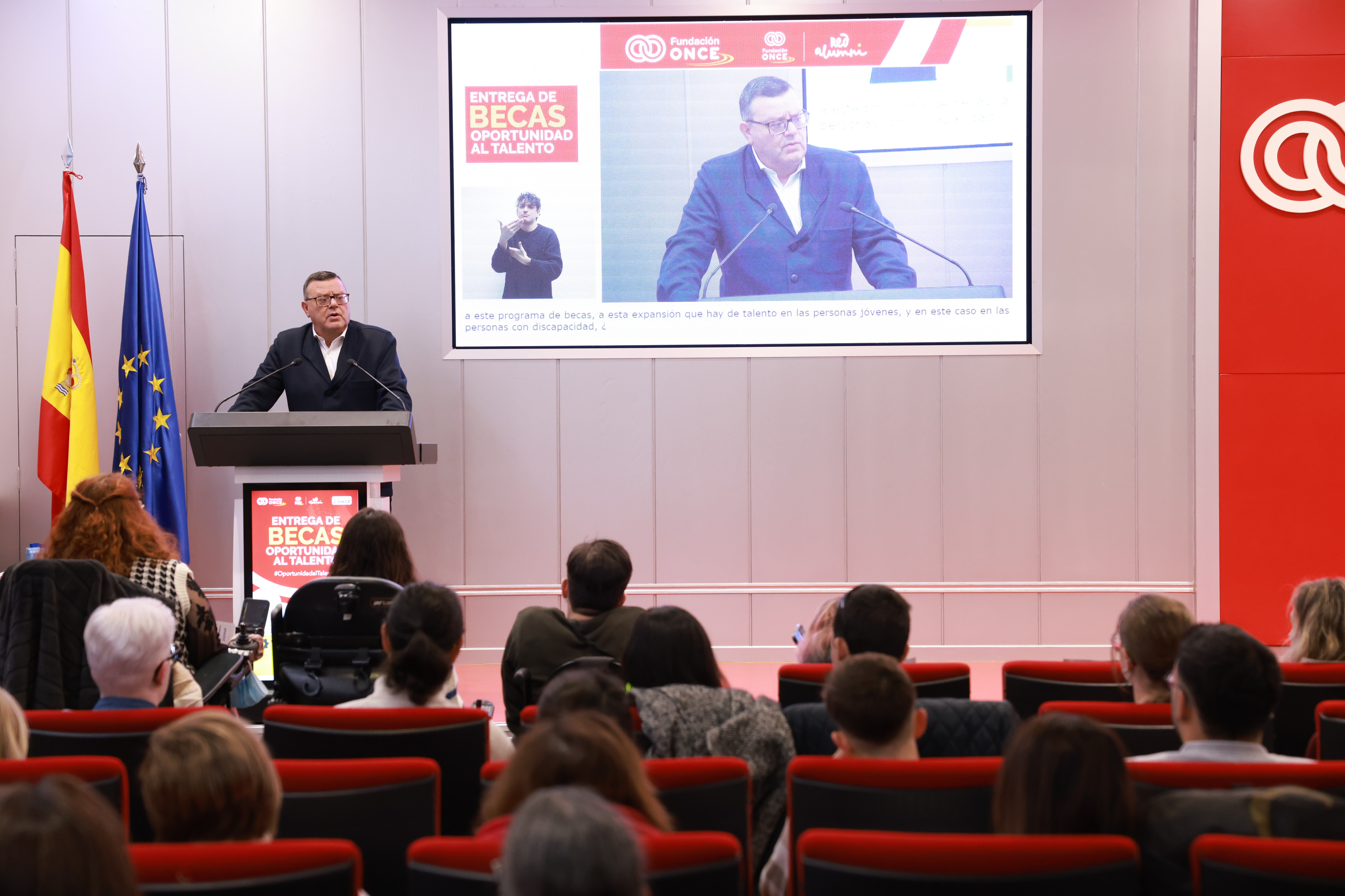 Foto del acto de la entrega de becas en la que se ve a José Luis Martínez Donoso hablando desde el atril y al público en las butacas
