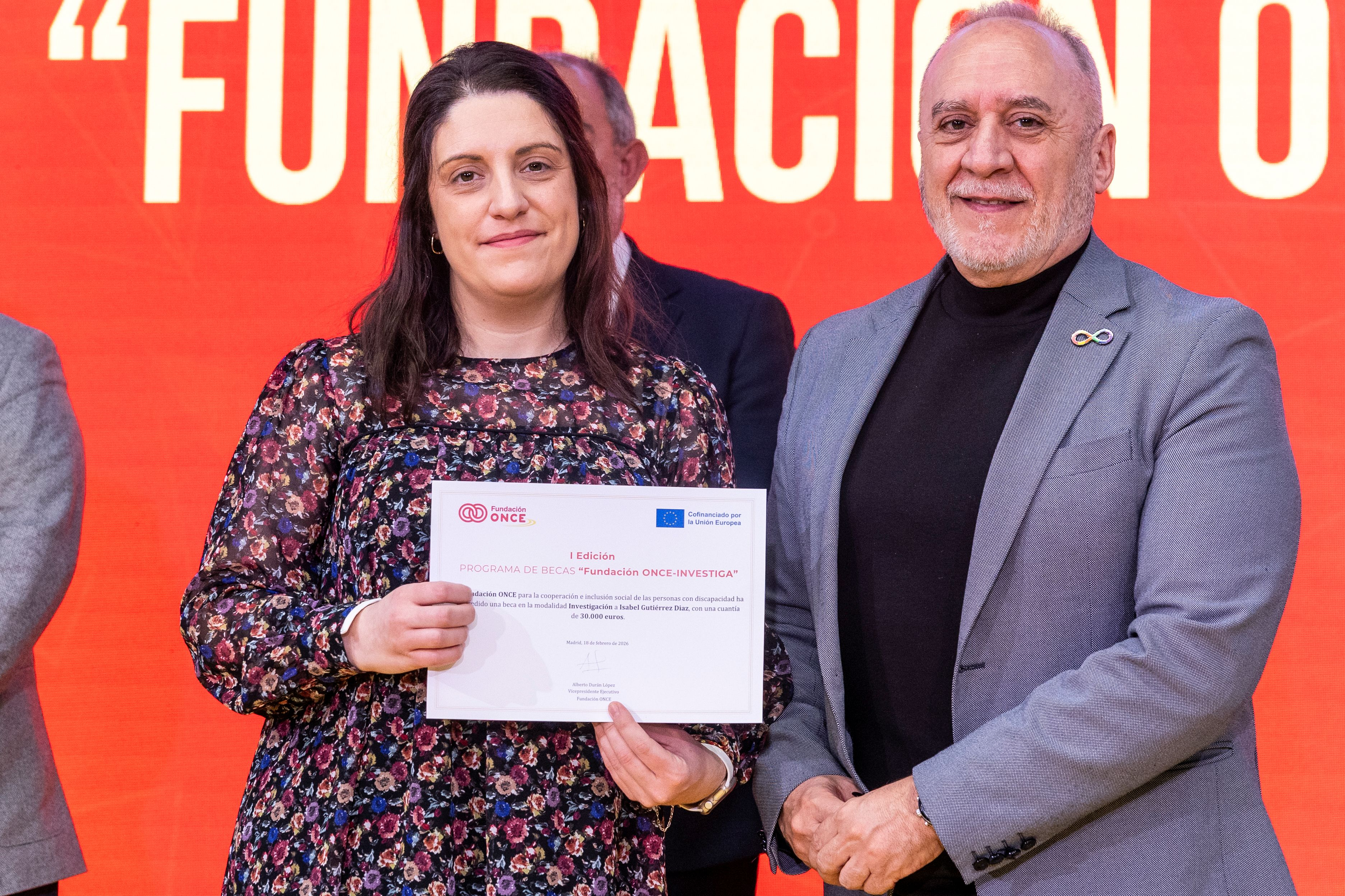 Foto de la becada mostrando el diploma