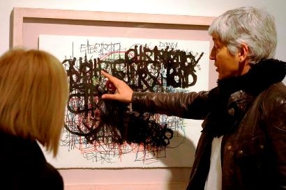 Foto de dos personas viendo una de las obras de la exposición