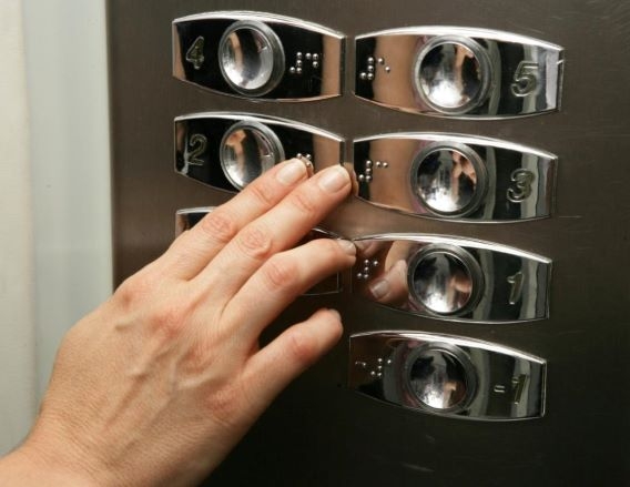 Imagen de una mano en la botonera interior de un ascensor