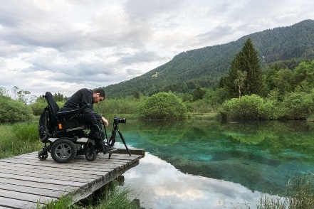 Foto de una persona en silla de ruedas haciendo turismo en un sitio con mucha naturaleza