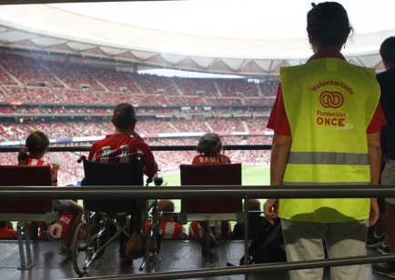 Foto de uno de nuestros voluntarios con personas con discapacidad en el estadio del atlético de Madrid