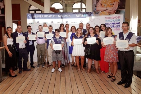 Foto de los graduados con los diplomas y los representantes de las entidades