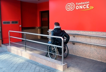 Foto de una persona en silla de ruedas entrando en la sede de Fundación ONCE