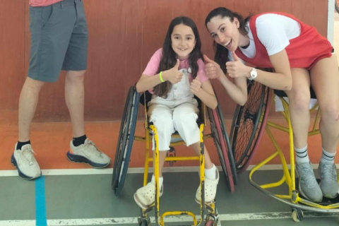 Dos niñas en silla de ruedas sonriendo.