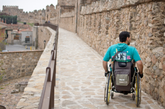 Imagen de úna persona en silla de ruedas en la ciudad de Ávila