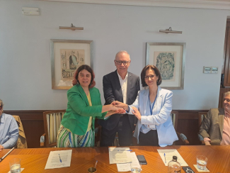 Foto de los firmantes estrechándose las manos