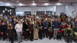 Fotografía de familia en el salón de actos de Fundación ONCE