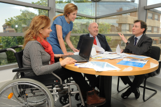 Fotografía de recurso con trabajadores alrededor de una mesa