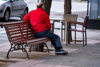 Fotografía de un hombre solo sentado en un banco