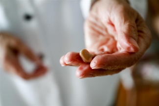 Fotografía de un mujer que sostiene en su mano un audífono