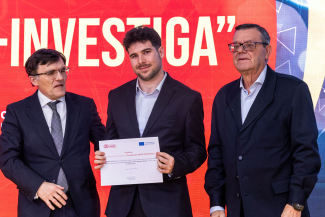 Foto del alumno becado mostrando el diploma