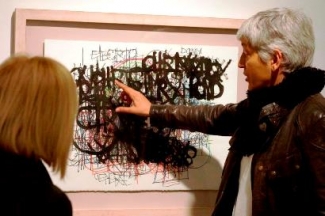 Foto de dos personas viendo una de las obras de la exposición