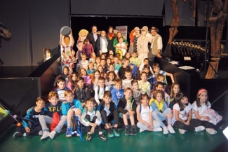 Foto de las personas que han presentado el cuento junto a un grupo de niños y niñas