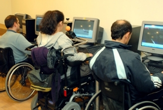 Foto de 3 personas en silla de ruedas frente al ordenador