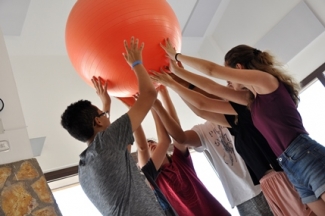 Foto de varias personas sujetando una pelota gran de goma