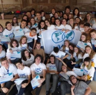 Foto de decenas de alumnos posando con la bandera del Colegio
