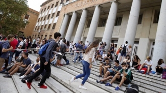 Fachada de Universidad Complutense de Madrid con estudiantes en las escaleras