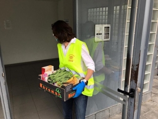 Voluntaria de Fundación ONCE repartiendo alimentos