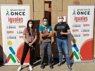 Imagen de tres personas con mascarillas entre dos traseras del Grupo Social ONCE
