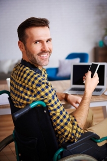 Foto de una persona en silla de ruedas delante de un ordenador