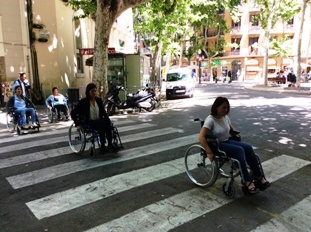 Fotos de empresarios subidos en sillas de ruedas paseando por la ciudad